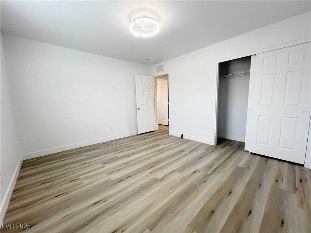 8821 Steaming Thunder Court Las Vegas, NV 89148 - Photo 20 of 31 Unfurnished bedroom with light wood-style floors and a closet