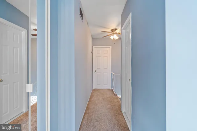 a view of a big room with windows and ceiling fan