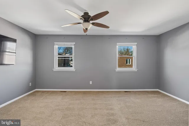 a living room with a ceiling fan and a window