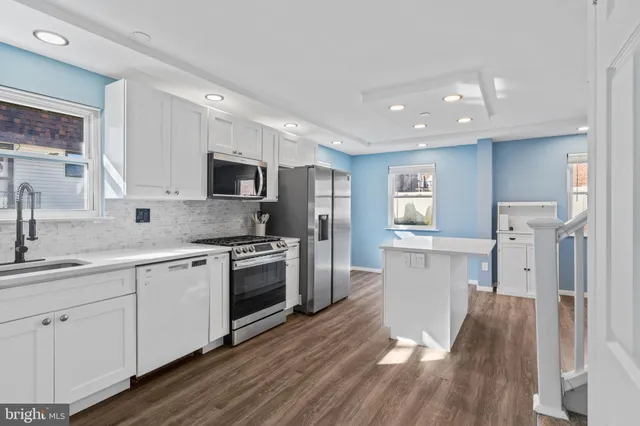 a kitchen with a sink stainless steel appliances and cabinets