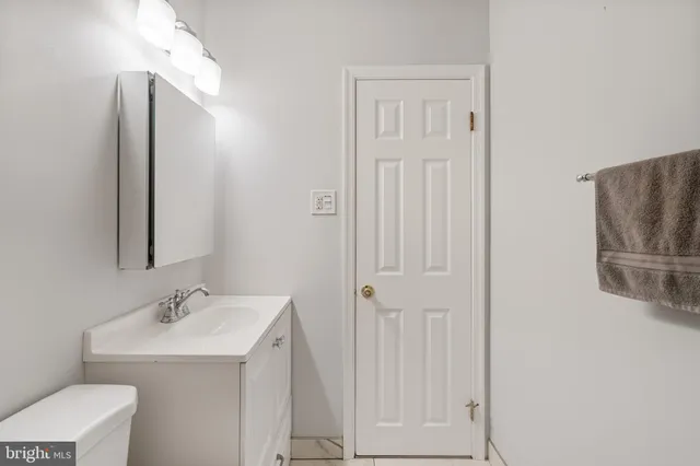a view of an empty room with wooden floor and stairs