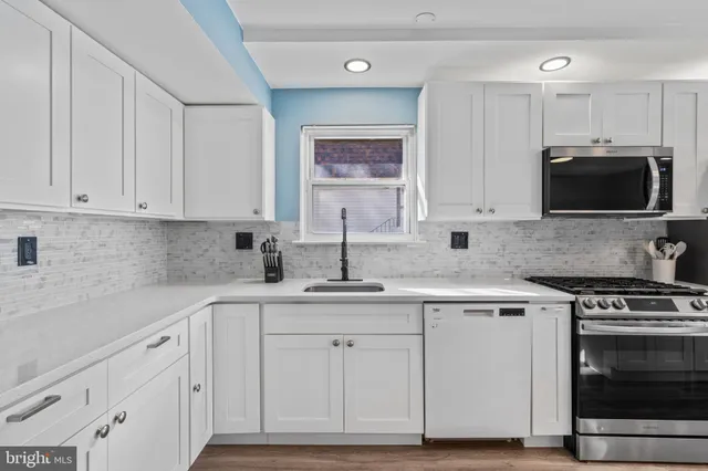 a kitchen with white cabinets and appliances