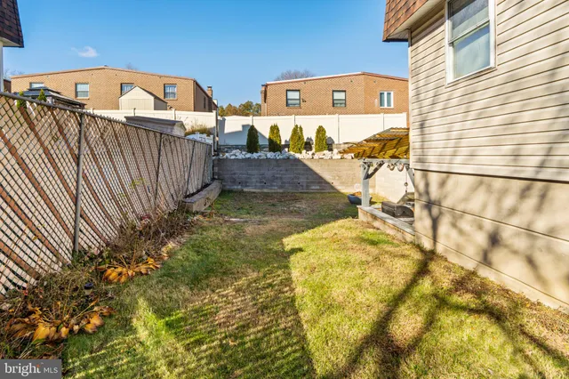 a view of a house with backyard and wooden fence