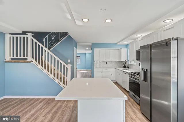 a kitchen with refrigerator and white cabinets