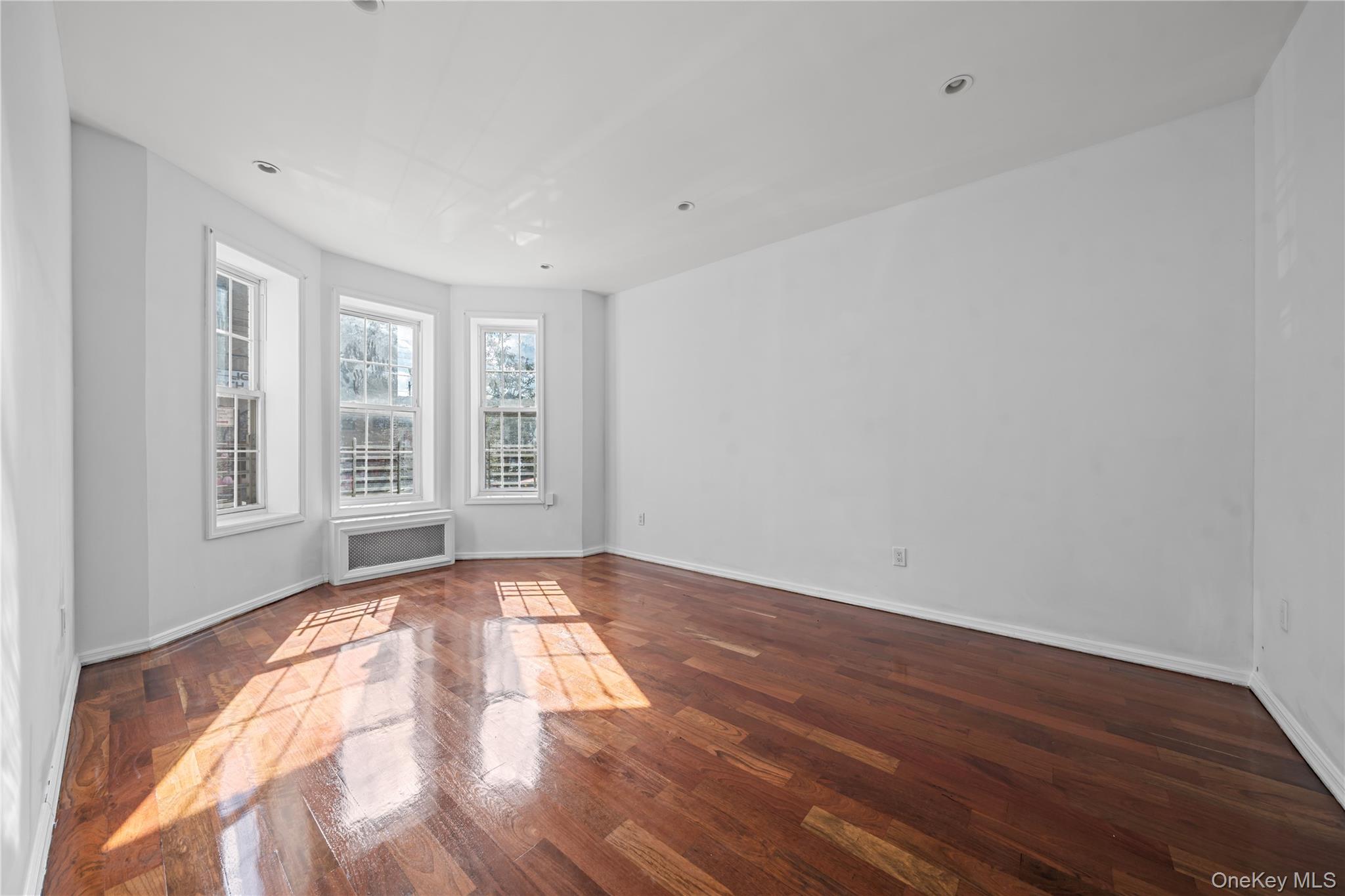1323 Sutter Avenue Brooklyn, NY 11208 - Photo 12 of 46 a view of an empty room with wooden floor and a window