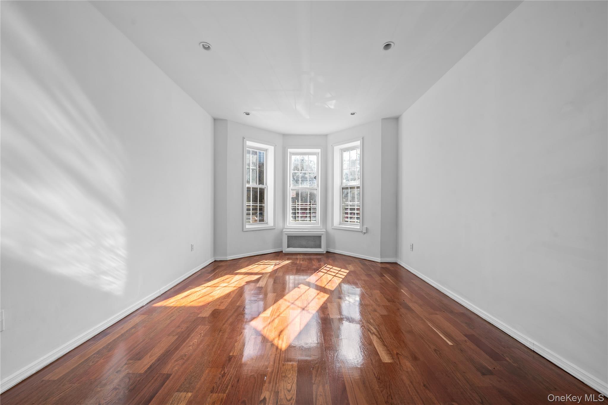 1323 Sutter Avenue Brooklyn, NY 11208 - Photo 13 of 46 a view of an empty room with wooden floor and a window