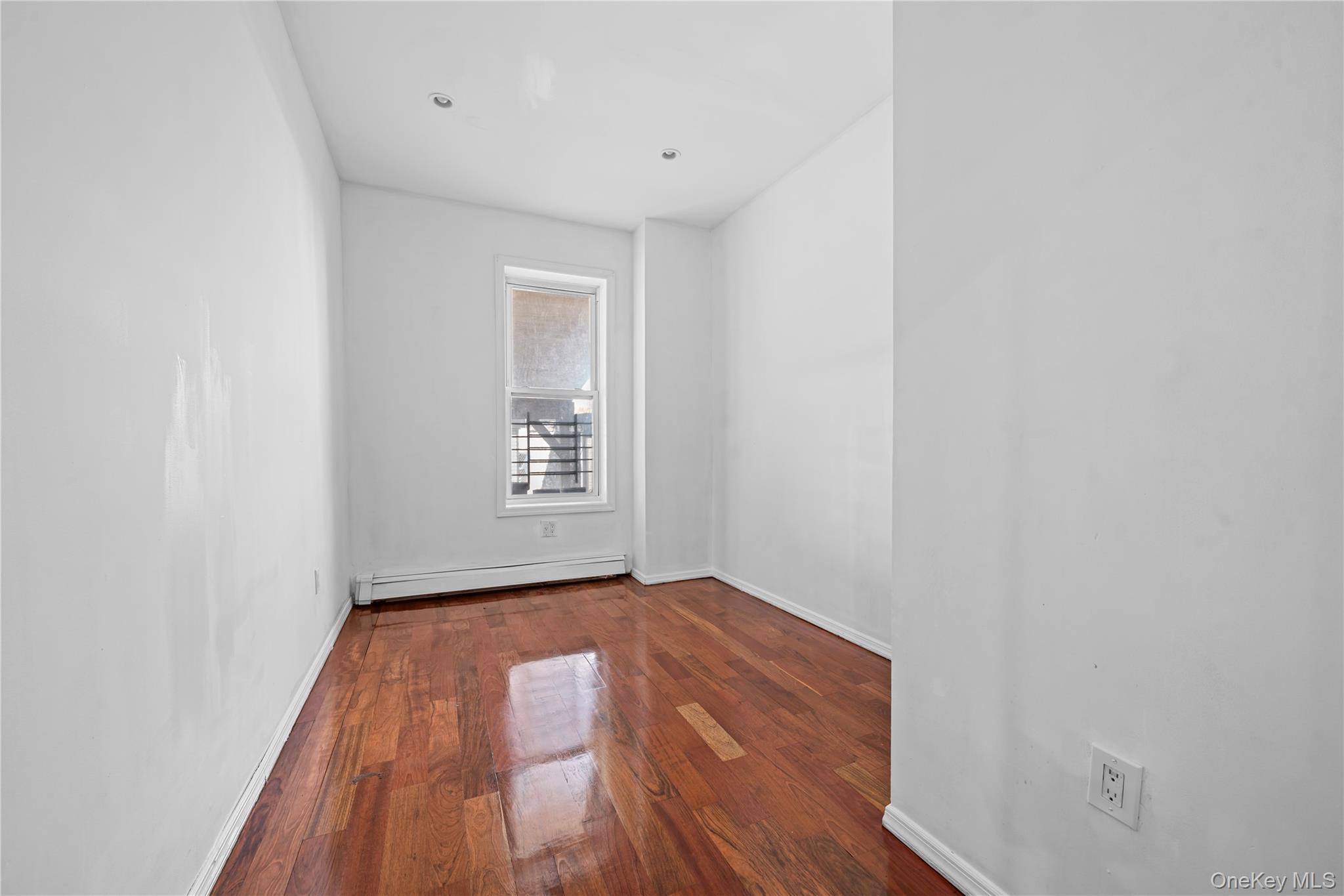 1323 Sutter Avenue Brooklyn, NY 11208 - Photo 14 of 46 a view of an empty room with wooden floor and a window