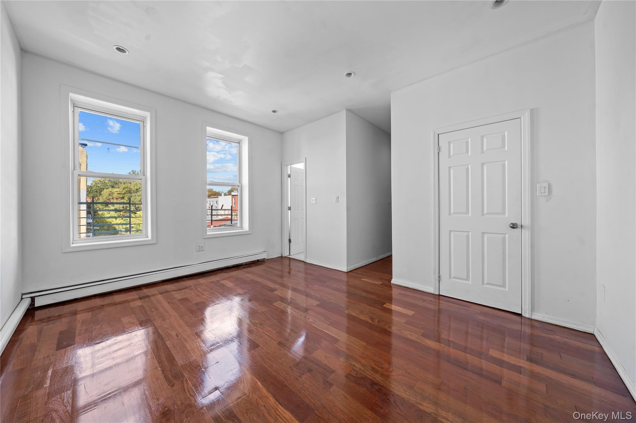 1323 Sutter Avenue Brooklyn, NY 11208 - Photo 17 of 46 an empty room with wooden floor and windows
