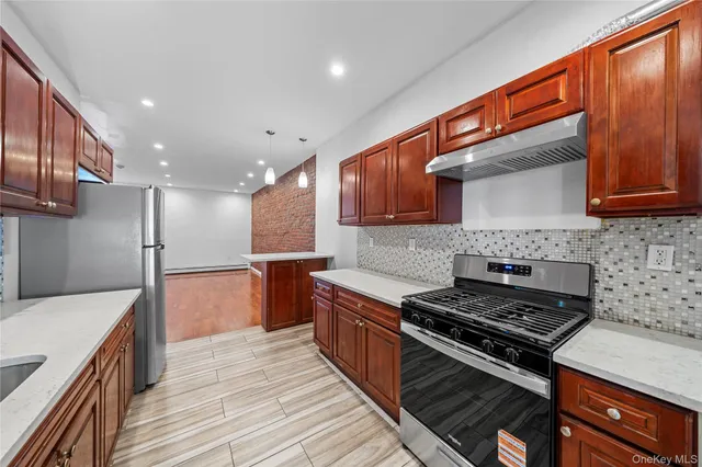a kitchen with stainless steel appliances granite countertop a stove a sink and a refrigerator