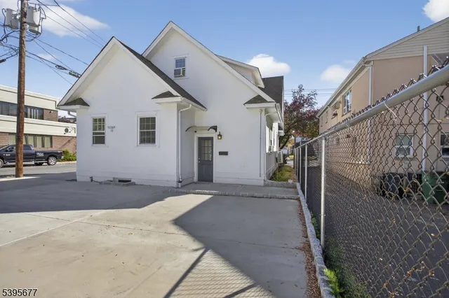 a view of a white house with a small yard in front of it