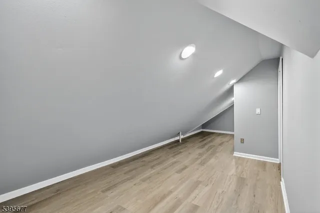 an empty room with wooden floor and white walls