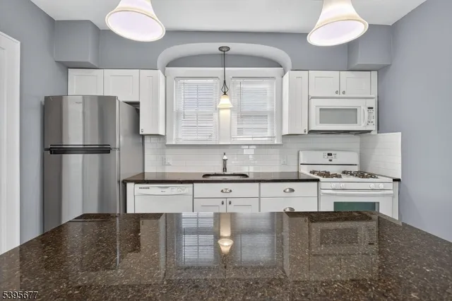 a kitchen with stainless steel appliances granite countertop a stove refrigerator sink and cabinets