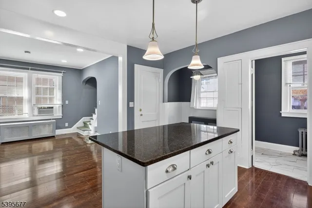 a kitchen with granite countertop a sink a counter space and wooden floor