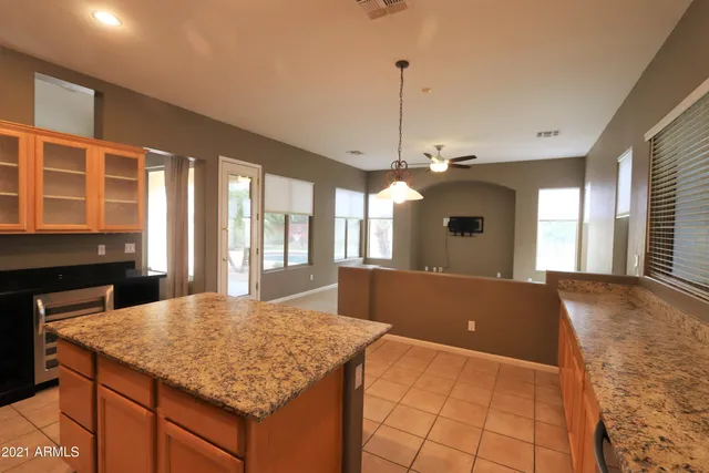 a view of kitchen with granite countertop sink and refrigerator