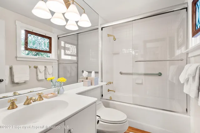 a bathroom with a sink a toilet and shower