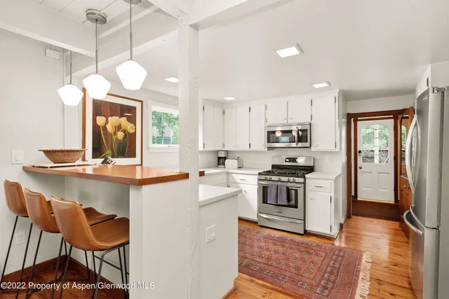 a kitchen with stainless steel appliances a stove a sink island and a refrigerator