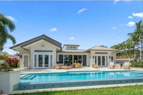 a front view of a house with swimming pool and porch with furniture