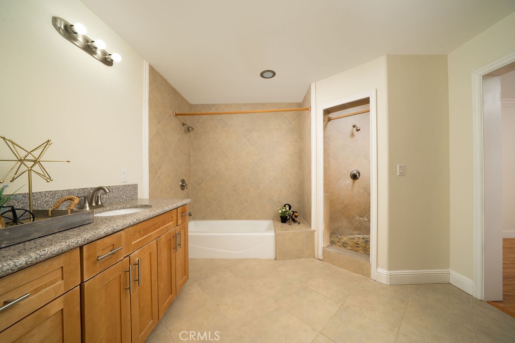 8851 Sonora Road Phelan, CA 92371 - Photo 15 of 26 a bathroom with a granite countertop sink a mirror a bathtub and shower