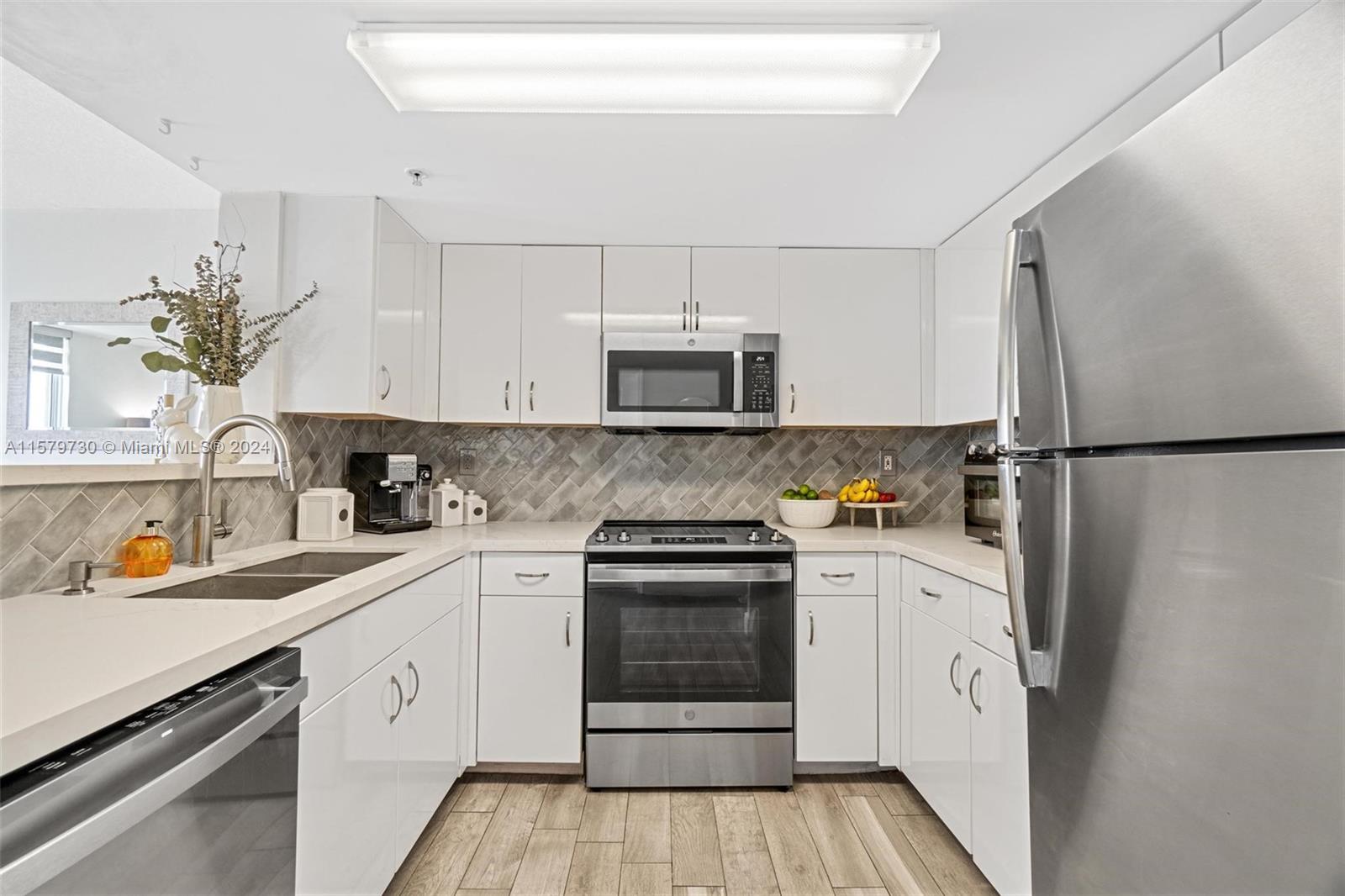 3000 Coral Way, Unit 703 Miami, FL 33145 - Photo 11 of 26 a kitchen with stainless steel appliances granite countertop a refrigerator sink and stove