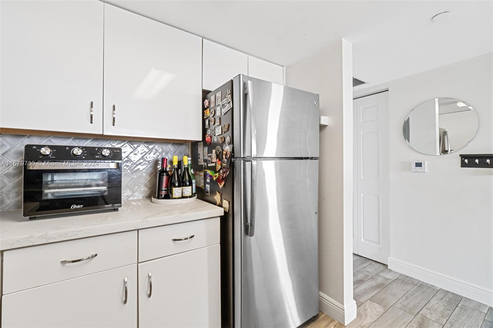 3000 Coral Way, Unit 703 Miami, FL 33145 - Photo 12 of 26 a kitchen with appliances a refrigerator and cabinets