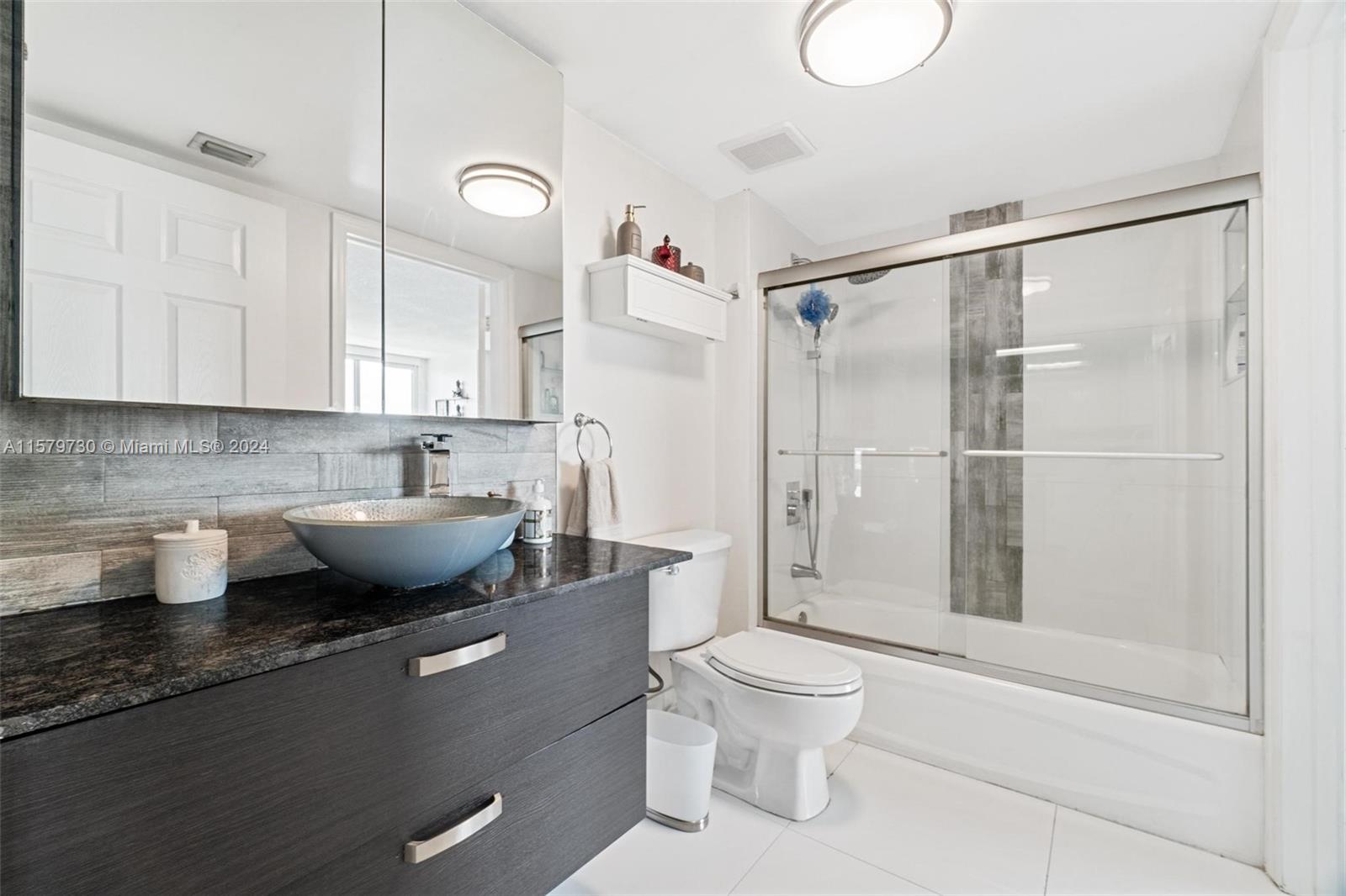 3000 Coral Way, Unit 703 Miami, FL 33145 - Photo 21 of 26 a bathroom with a granite countertop sink a toilet and shower