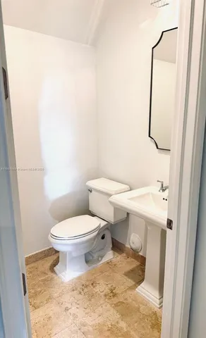 a white toilet sitting next to a white sink