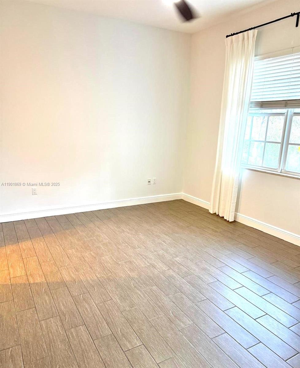 7765 Southwest 54th Court, Unit 7765 Miami, FL 33143 - Photo 13 of 30 an empty room with wooden floor and windows