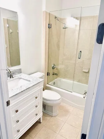 a bathroom with a granite countertop sink toilet mirror and shower