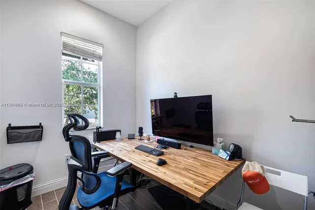 a view of a workspace with furniture and a window