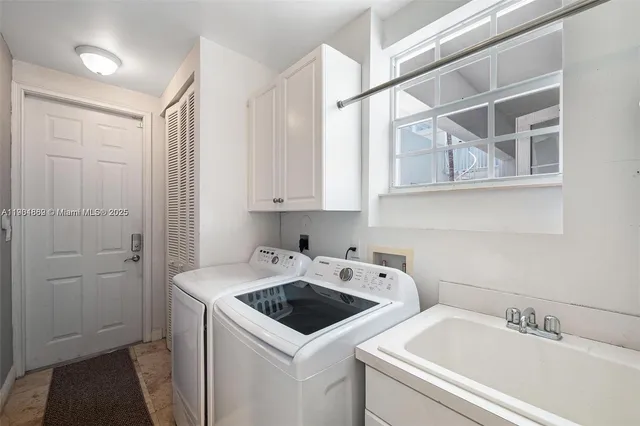 a view of a utility room with sink dryer and washer