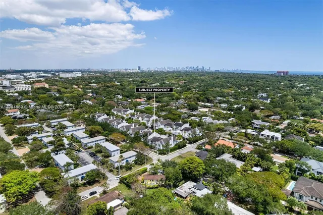 an aerial view of residential houses with outdoor space and trees