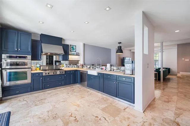 a large kitchen with wooden floors and stainless steel appliances
