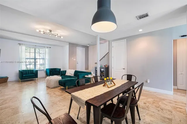 a view of a dining room with furniture and a chandelier