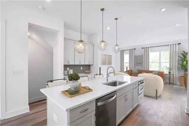 a kitchen with a sink stove and wooden floor