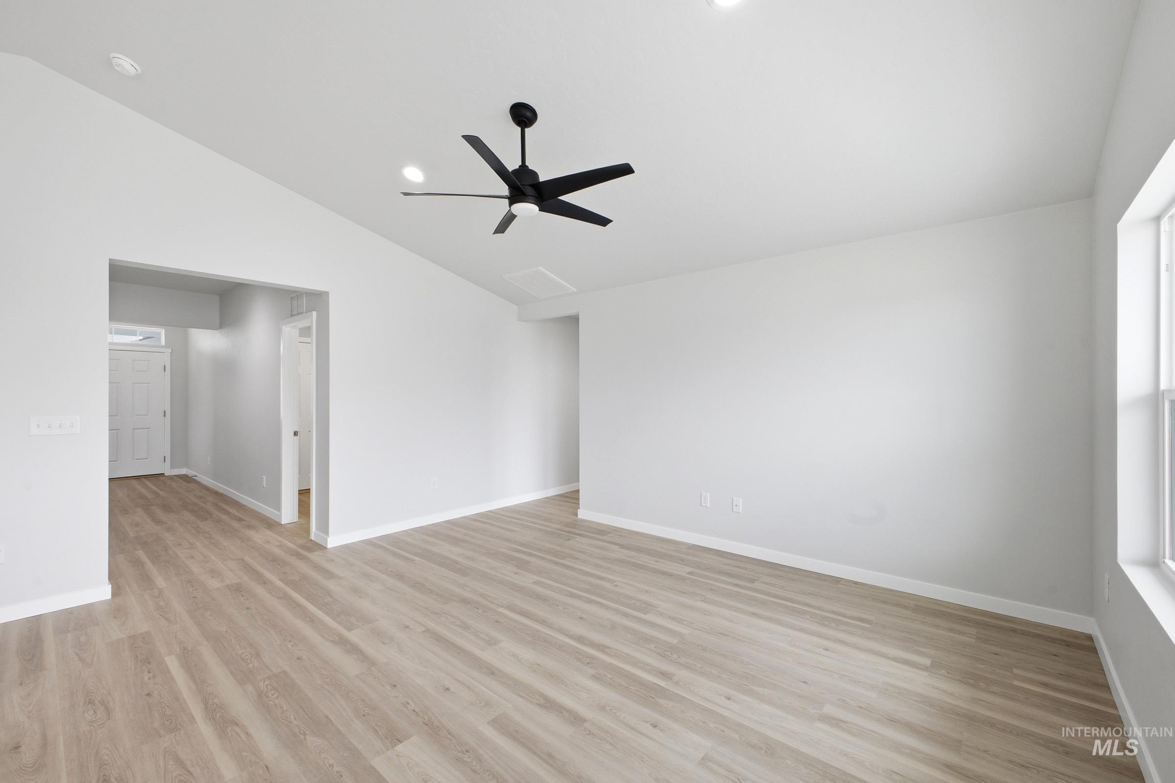 1598 Sunday River Street Middleton, ID 83644 - Photo 8 of 17 Spacious room featuring vaulted ceilings, light wood-finish flooring, a contemporary black ceiling fan, recessed lighting, and a large window