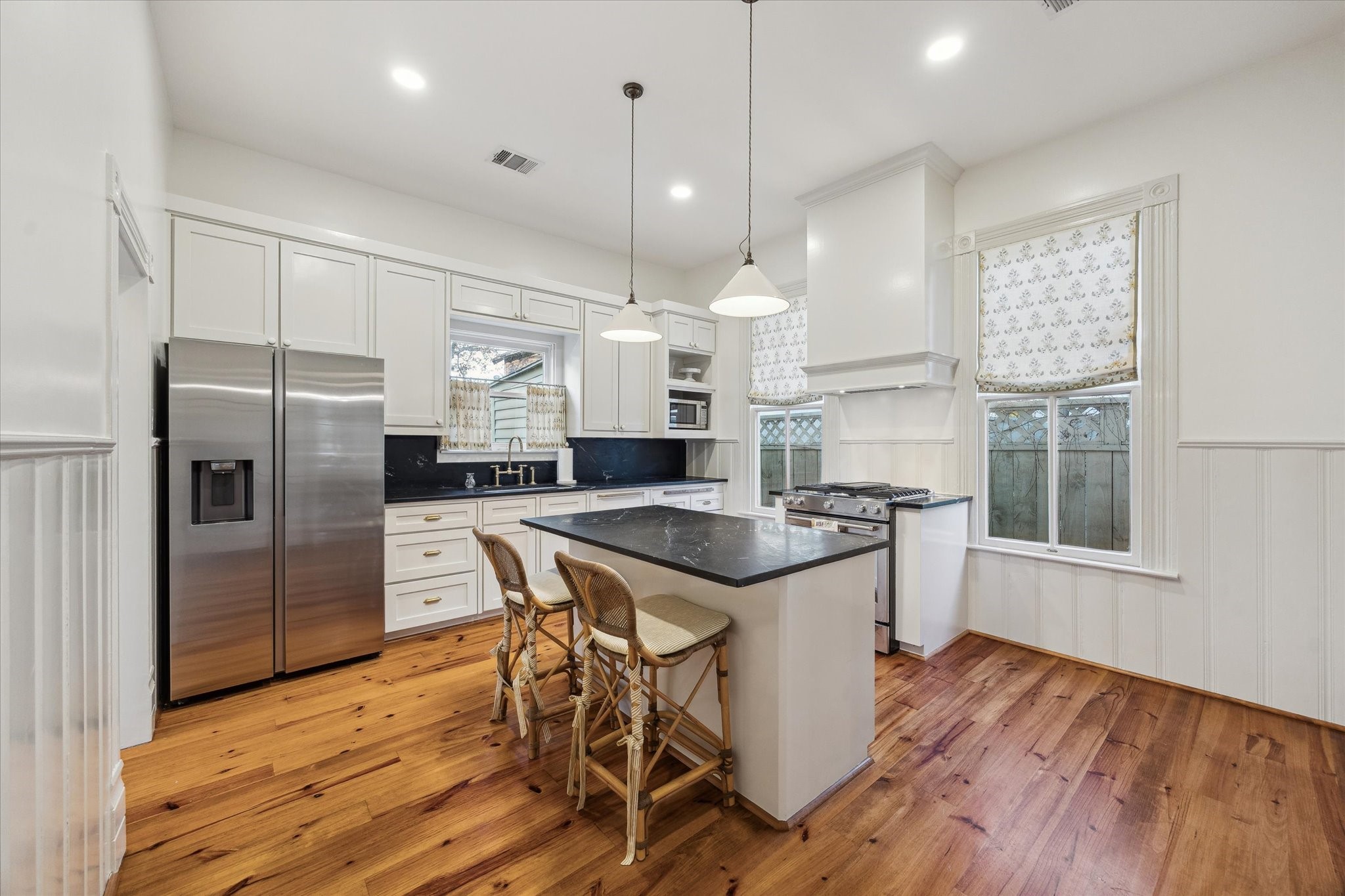 307 Archer Street Houston, TX 77009 - Photo 10 of 26 a kitchen with stainless steel appliances granite countertop a stove a refrigerator a sink a dining table and chairs with wooden floor