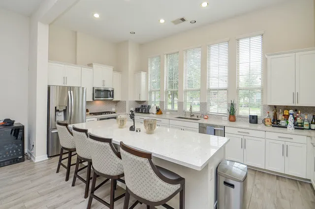 a kitchen with a dining table chairs and refrigerator