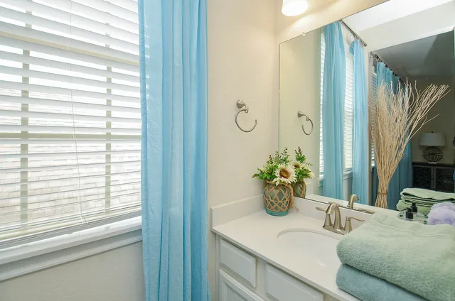 a bathroom with a granite countertop sink a large mirror and a window
