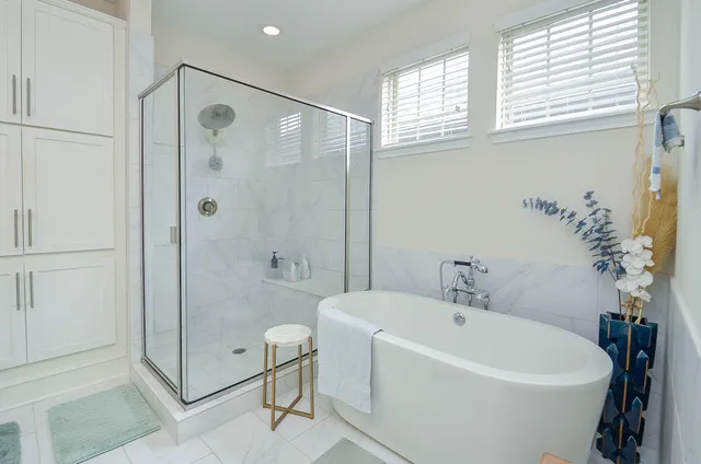 a white bath tub sitting next to a shower