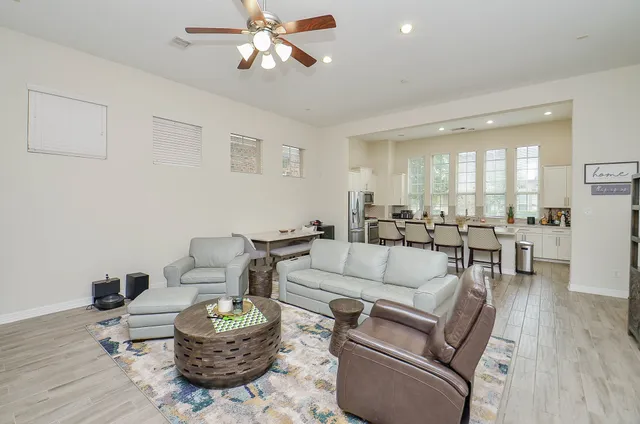 a living room with furniture and a view of kitchen