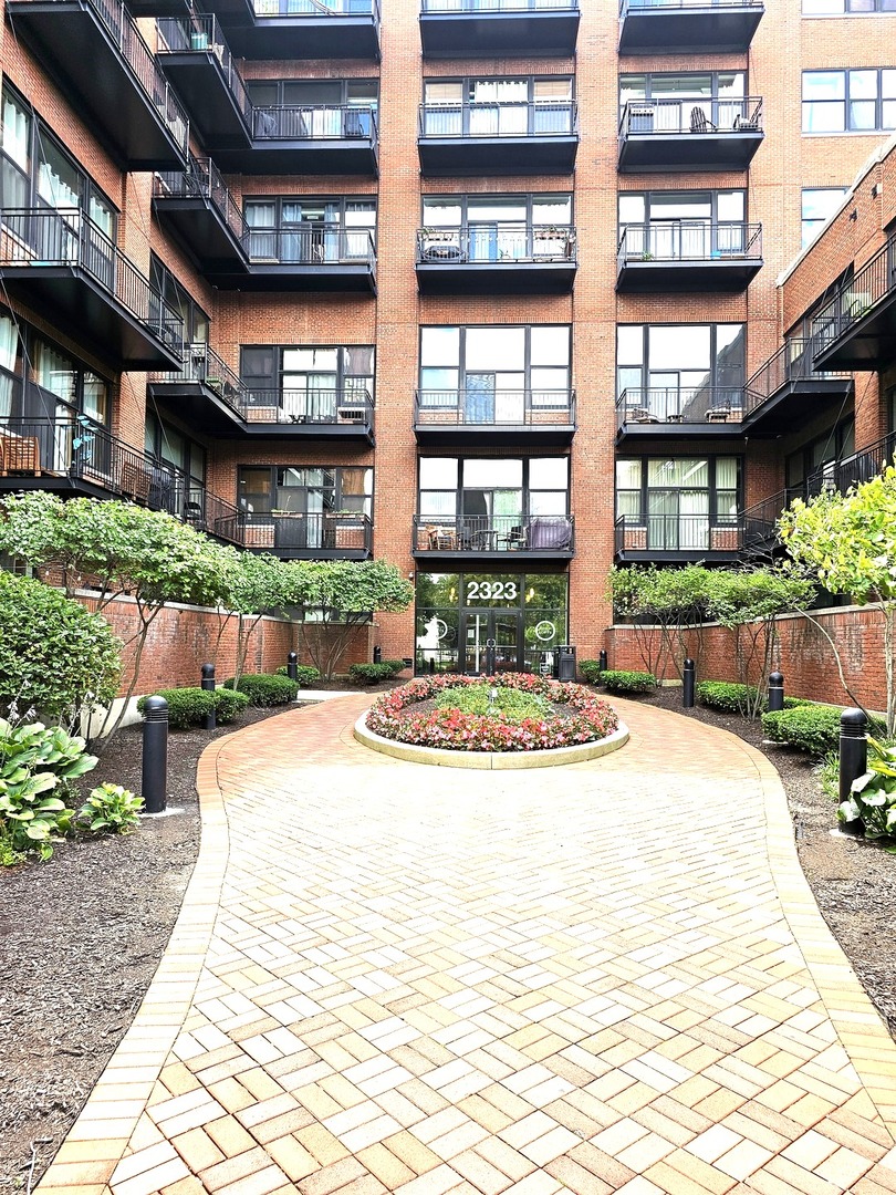 2323 West Pershing Road, Unit 230 Chicago, IL 60609 - Photo 2 of 39 a front view of a building with a garden and plants