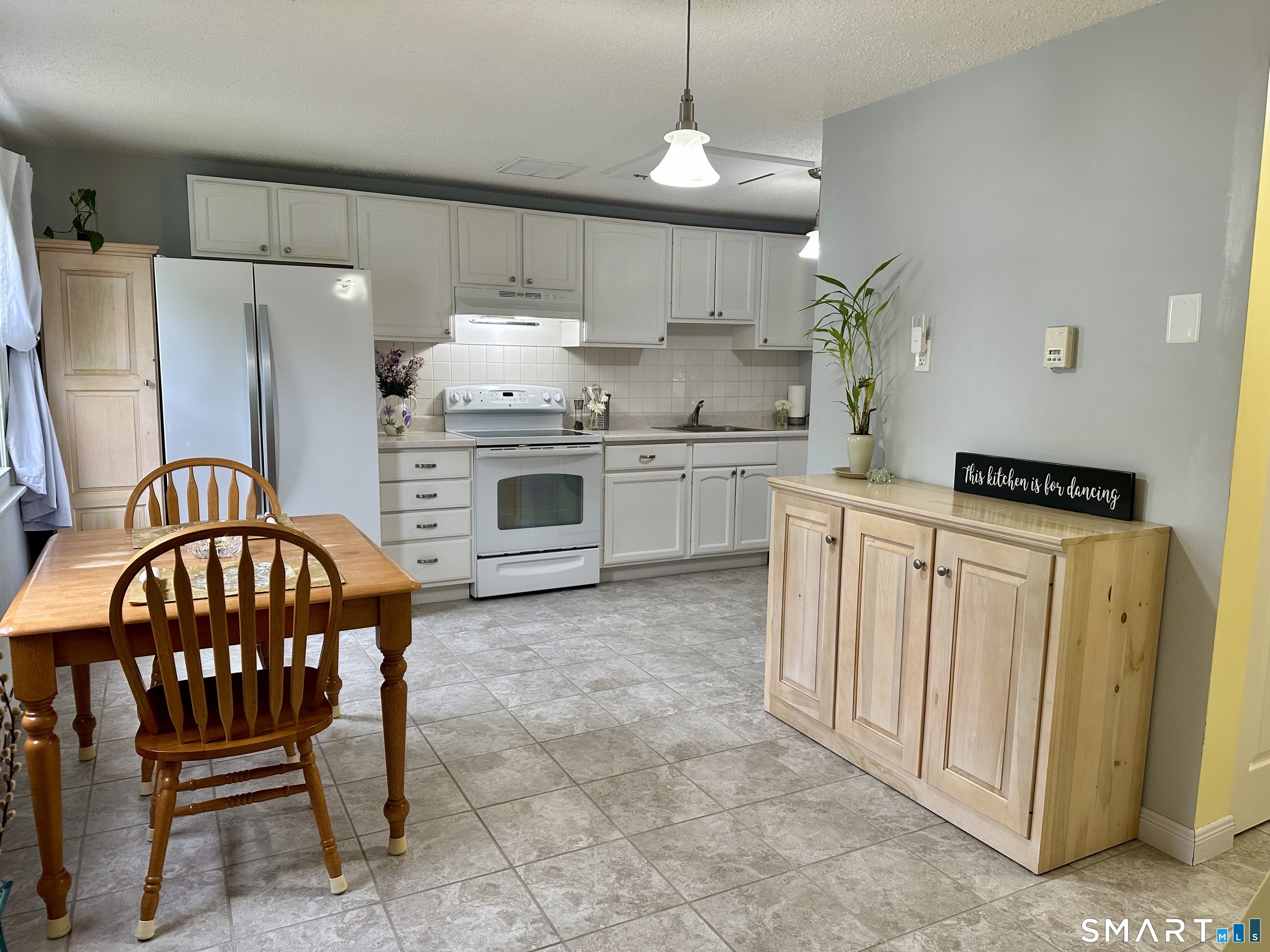 2 Lakeside Drive, Unit M Ledyard, CT 06339 - Photo 4 of 38 a kitchen with stainless steel appliances granite countertop a stove a sink a dining table and chairs