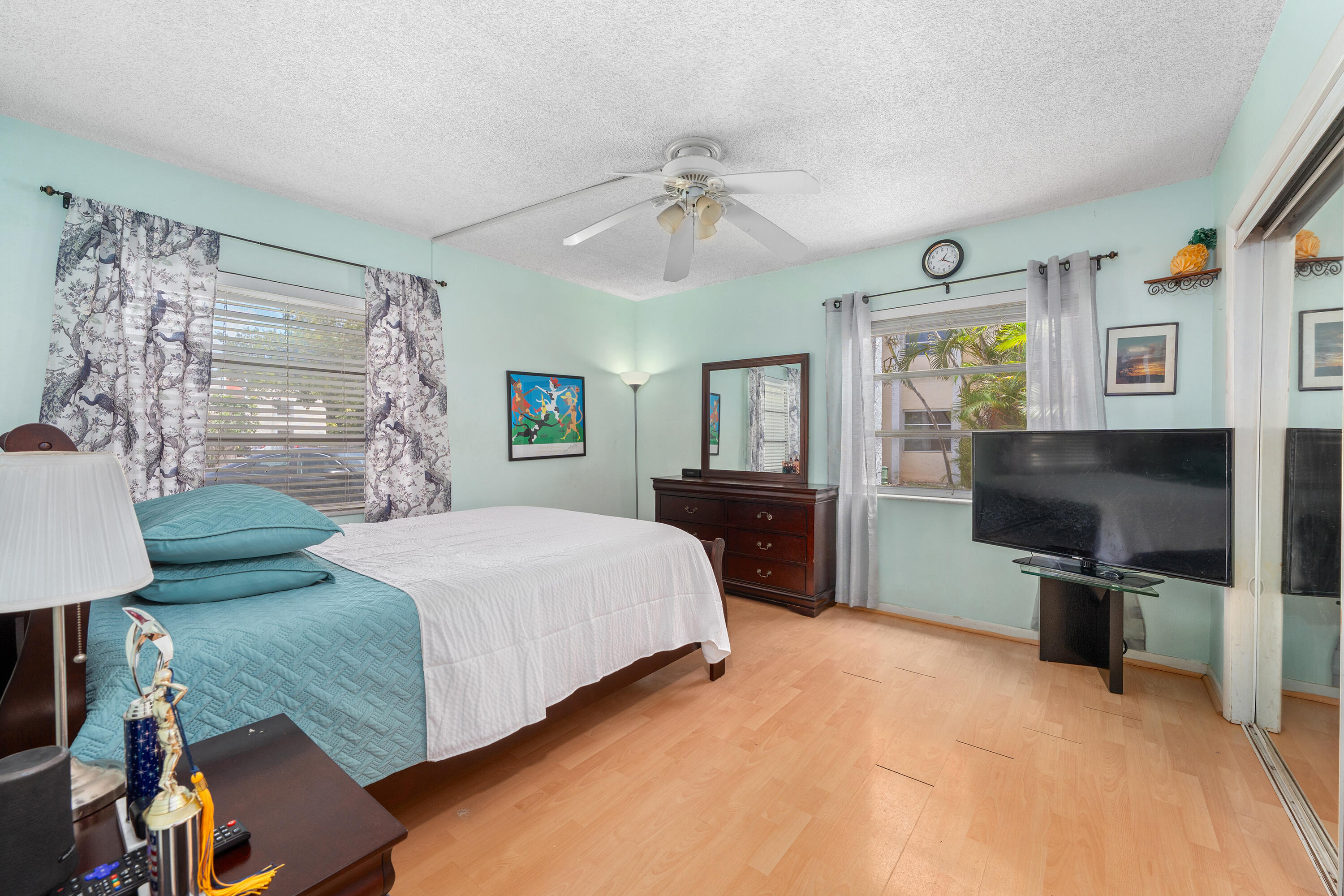 628 Northwest 13th Street, Unit 11 Boca Raton, FL 33486 - Photo 11 of 22 a spacious bedroom with a bed and a flat screen tv