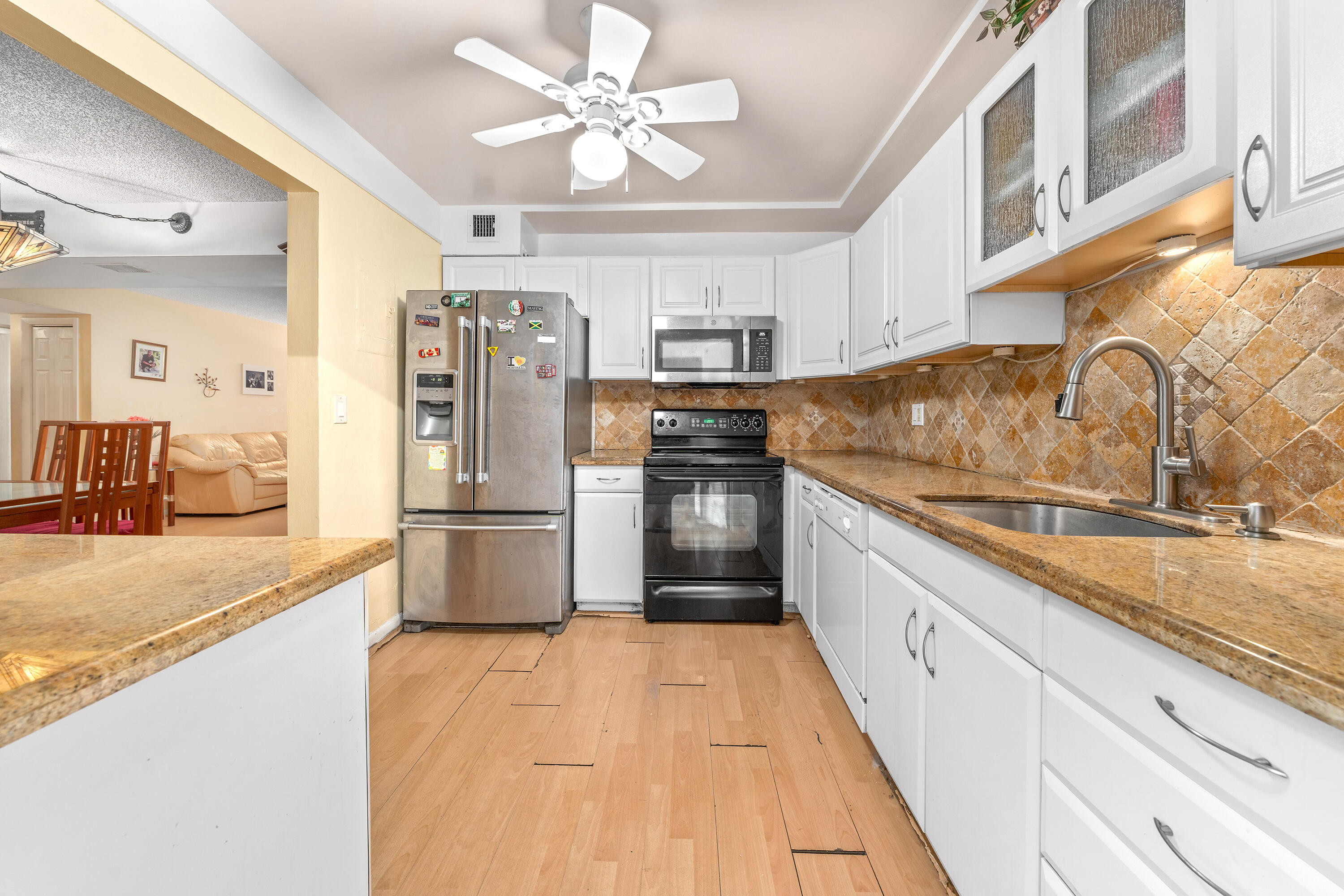 628 Northwest 13th Street, Unit 11 Boca Raton, FL 33486 - Photo 5 of 22 a large kitchen with stainless steel appliances granite countertop a sink and cabinets