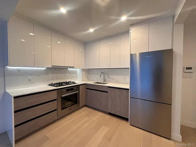 a kitchen with stainless steel appliances granite countertop a refrigerator and a stove