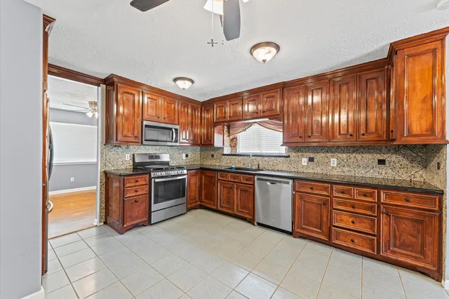 a kitchen with stainless steel appliances granite countertop a stove sink and cabinets