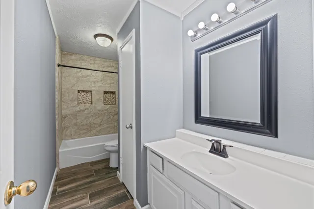 a bathroom with a granite countertop sink vanity granite tub and a mirror