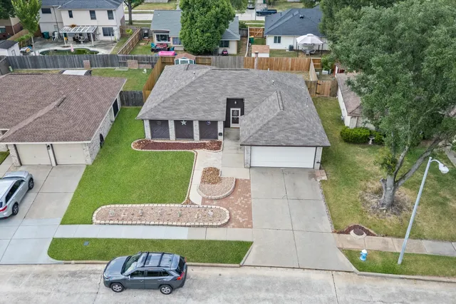 an aerial view of a house with garden space and street view