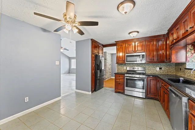 a kitchen with stainless steel appliances granite countertop a refrigerator and a sink