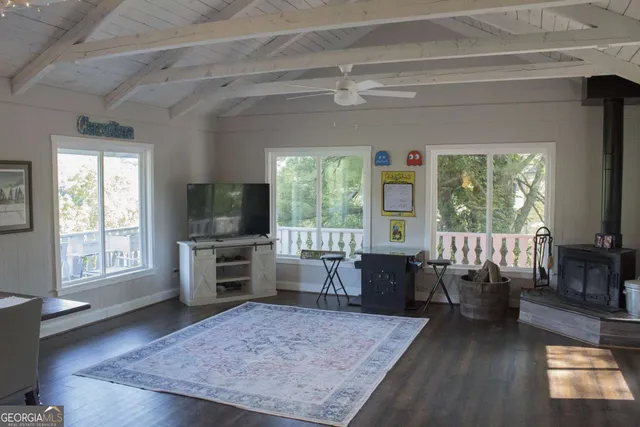 a living room with furniture flat screen tv and windows